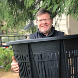 Man holding a 25 gallon RediRoot plastic air-pruning pot outdoors